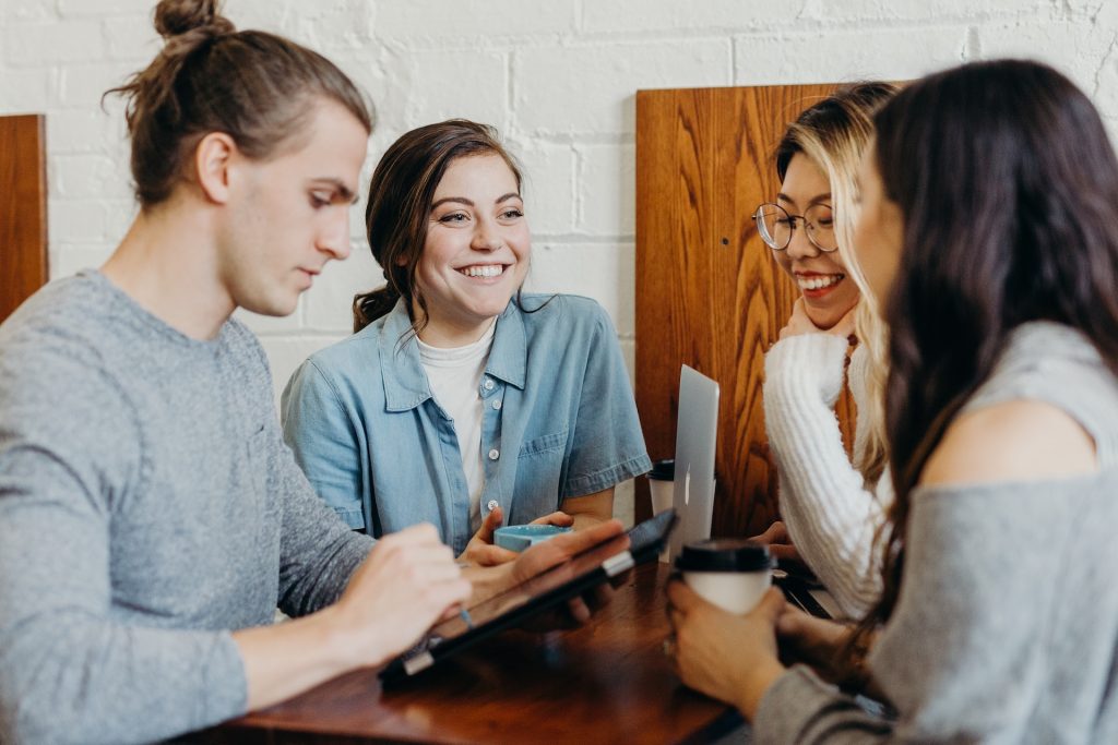 A group of friends laughing at a coffee shop