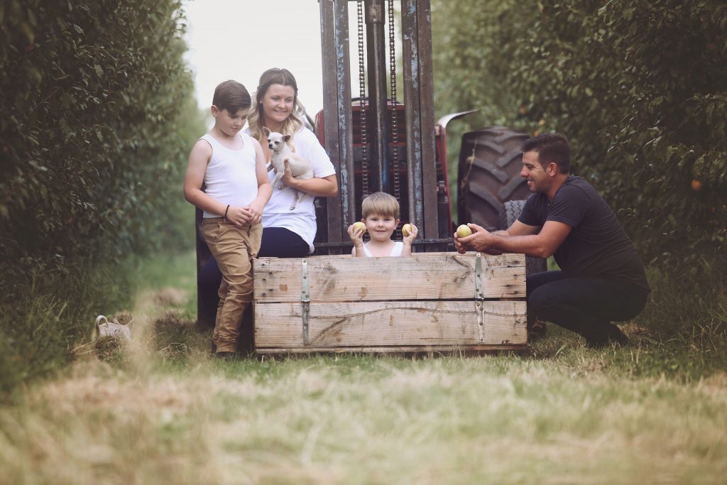 Photograph of Liza Kalogerias and family in an orchard