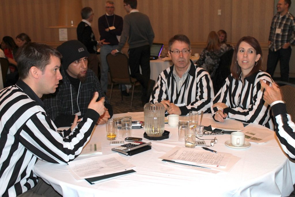 Photograph of a team sitting around a table playing in a Drought Tournament.