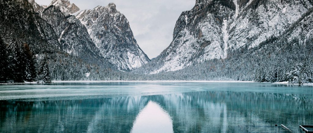 Photograph of snow-covered mountains and a lake.