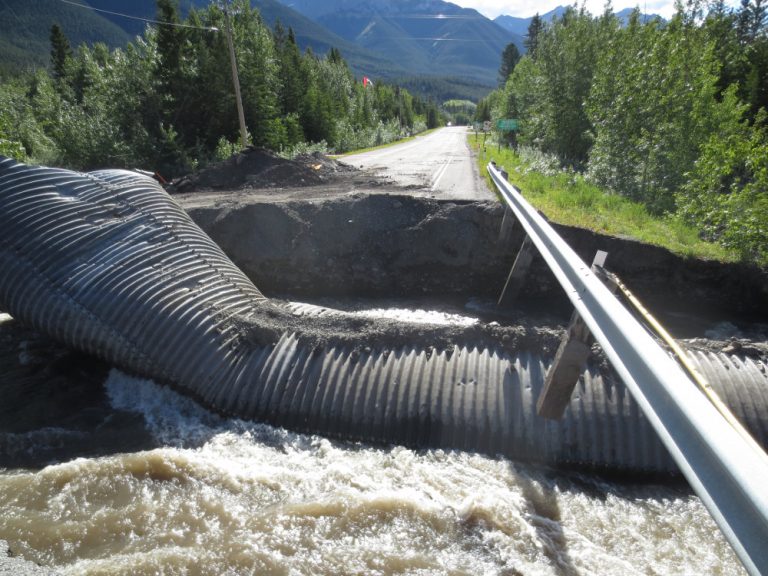 Photograph of a washed-away bridge and destroyed culvert