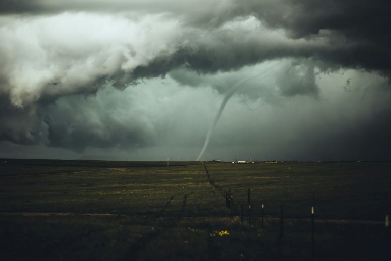 Photograph of a tornado funnel near some buildings