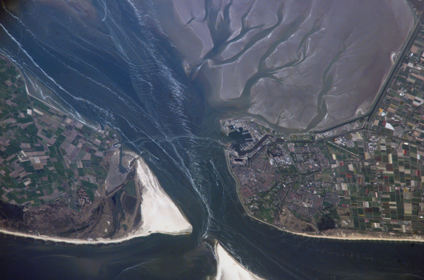 A photo taken by NASA of the city and harbor of Den Helder. Extensive gray mudflats can be seen in the top right of the photo.