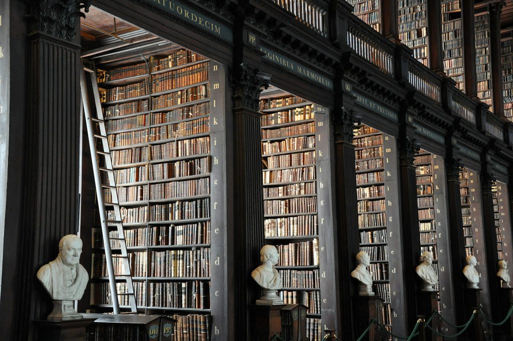 A photograph of an library with many old books in many shelves and alcoves