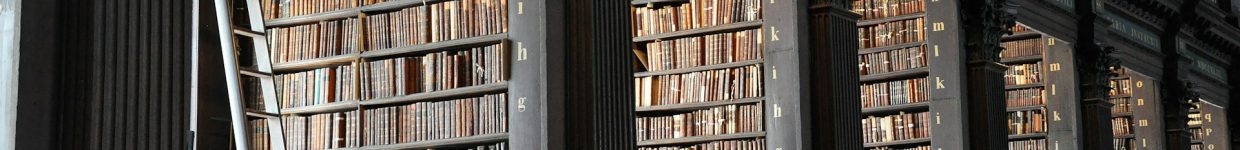 A photograph of an library with many old books in many shelves and alcoves